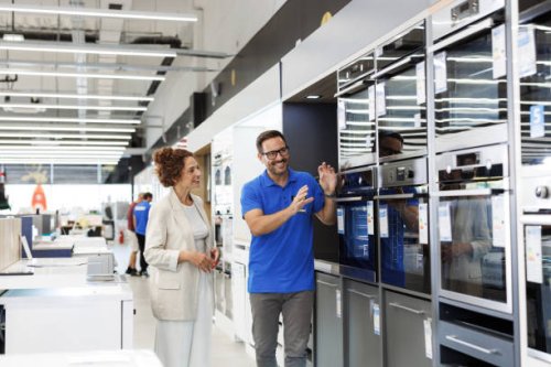 salesperson presenting oven to a customer in an appliance store - home decoration stock pictures, royalty-free photos & images