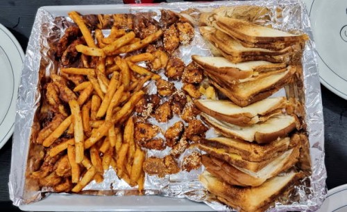 sandwiches, chicken and potato fries in a tray covered with silver foil. - junk food stock pictures, royalty-free photos & images