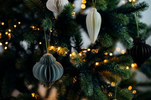 scandinavian christmas paper honeycomb ornament on christmas tree with lights. modern christmas decoration. - home decoration stock pictures, royalty-free photos & images
