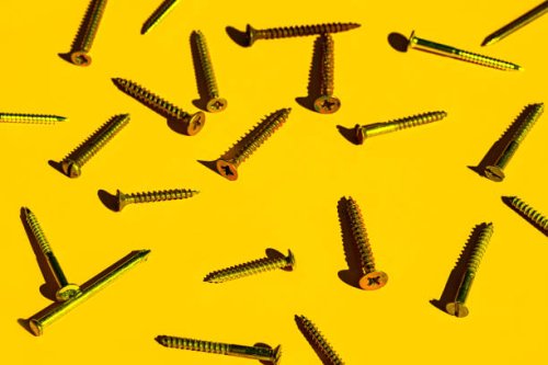 scattered screw nails on yellow color background. - nails art photos et images de collection