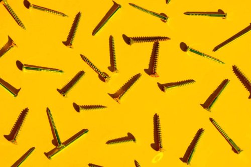 scattered screw nails on yellow orange color background. - nails art stock pictures, royalty-free photos & images