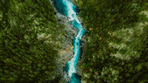 scenic aerial view of the mountain landscape with a forest and the crystal blue river in jotunheimen national park - travel stock pictures, royalty-free photos & images