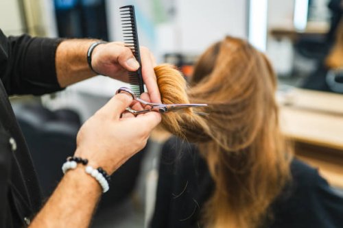 schöne junge frau, die sich die haare schneiden lässt - hairstyle stock-fotos und bilder