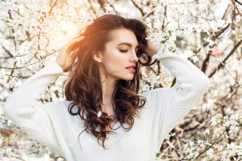 schönes mädchen auf dem hintergrund des frühlingsbuschs - fashion stock-fotos und bilder