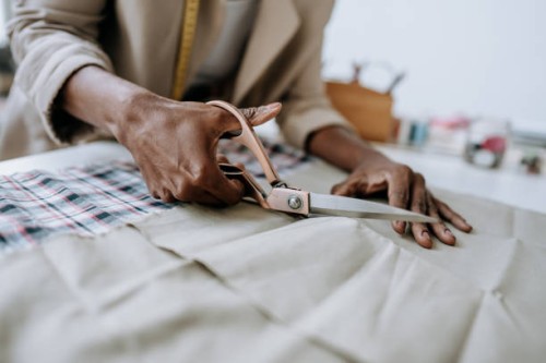 seamstress cutting fabric foreground - fashion stock pictures, royalty-free photos & images