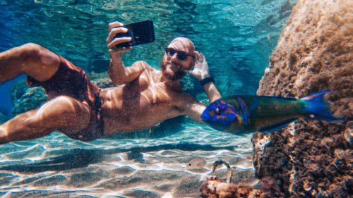 selfie with mobile phone underwater at sea: fish photobombing - travel stock pictures, royalty-free photos & images