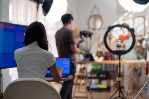 selling live stream online marketing behind back office woman programer checking selling statistic from application screen between stylish influencer woman broadcast selling cloth online sme small business e-commerce - fashio
