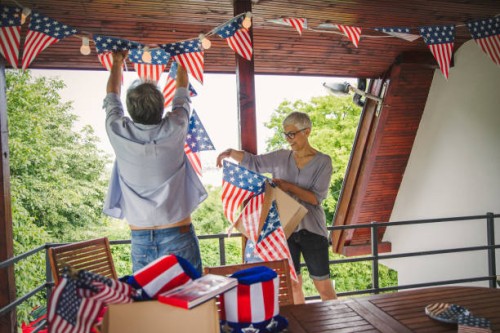 senior couple decorating outdoor deck - garden decoration stock pictures, royalty-free photos & images
