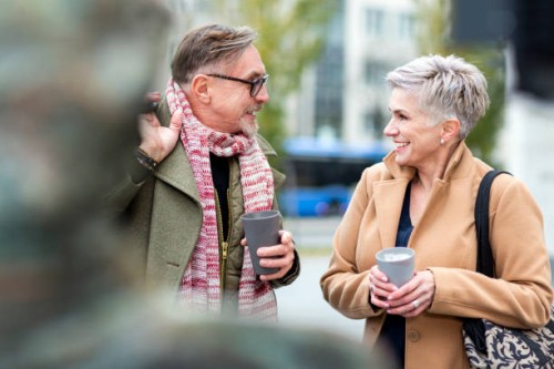 senior couple enjoying coffee to go and talking - junk food stock pictures, royalty-free photos & images