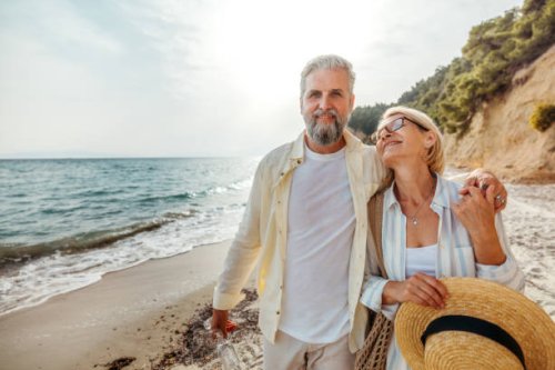 senior couple enjoying day on a beach - travel stockfoto's en -beelden