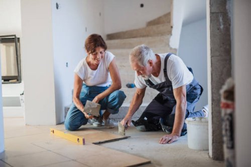 senior couple laying tile floor in new home. - home decoration stock pictures, royalty-free photos & images