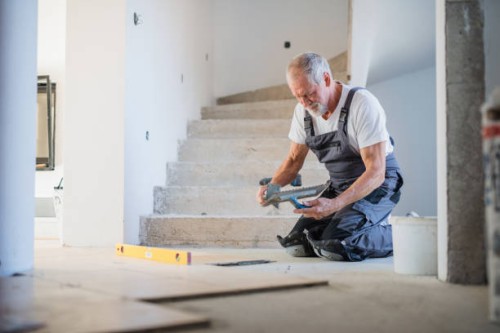 senior man laying tile floor in new home. - home decoration fotografías e imágenes de stock