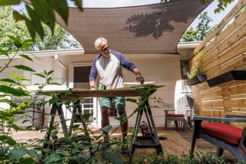 senior man measuring wood plank in back yard - home decoration stock pictures, royalty-free photos & images