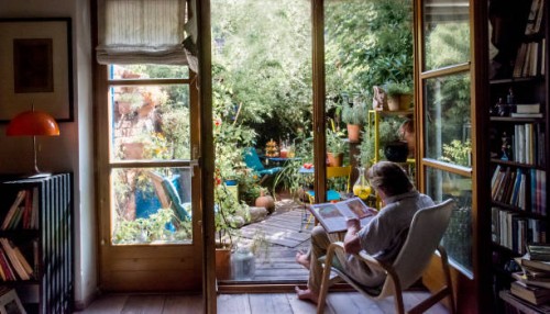 senior man reading book on armchair at home - garden decoration photos et images de collection