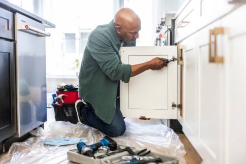 senior man repairing kitchen cabinet at home - home decoration stock pictures, royalty-free photos & images