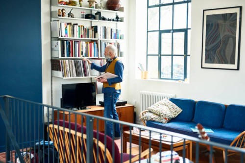 senior man sorting through his record collection in living room - home decoration stock pictures, royalty-free photos & images
