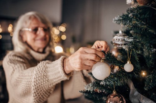 senior woman decorating christmas tree at home - home decoration stock pictures, royalty-free photos & images