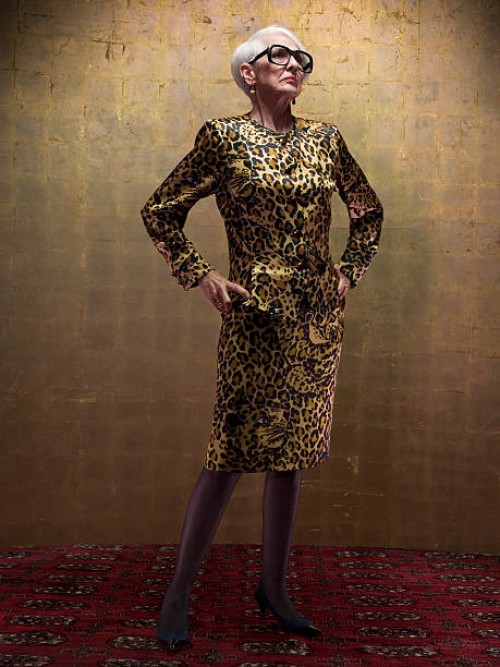 senior woman wearing leopard print dress standing in studio - fashion stock pictures, royalty-free photos & images