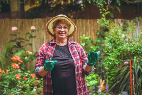 senior woman with flowers in garden - garden decoration stock pictures, royalty-free photos & images