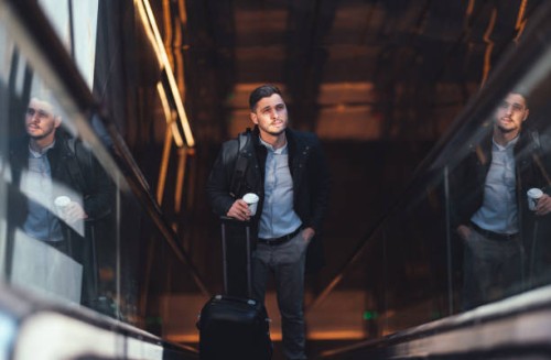 serious businessman riding escalator at subway station - junk food stock pictures, royalty-free photos & images
