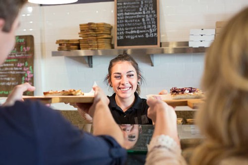 server handing pizza to customers in cafe - junk food stock pictures, royalty-free photos & images