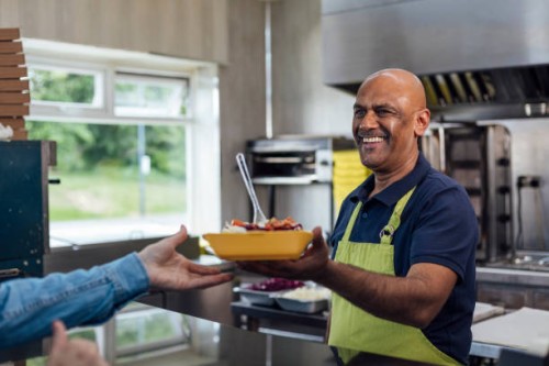 serving a customer at a takeaway shop - junk food stock pictures, royalty-free photos & images