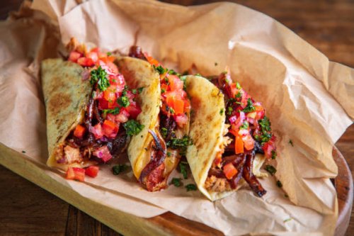 serving of tacos with shredded roast pork and cheese filling on brown paper in wooden plate - junk food stock pictures, royalty-free photos & images