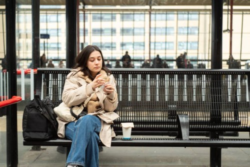 she is eating a sandwich in train station - junk food stock pictures, royalty-free photos & images