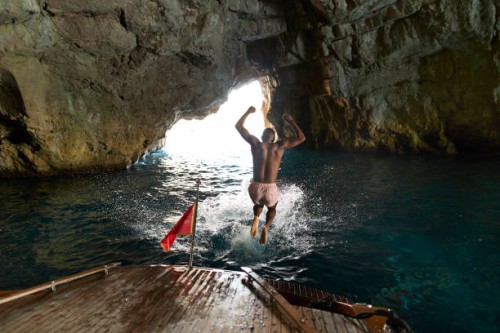 shirtless young man jumping in sea - travel photos et images de collection