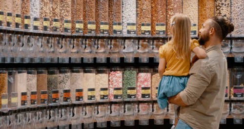 shopping, choice and father with child choosing snacks and food in a grocery supermarket. retail store, shop and dad and daughter picking candy, sweet or nuts for nutrition and diet to buy - junk food stock pictures, royalty-