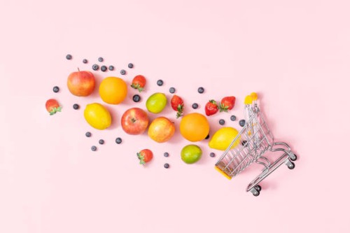 shopping trolley with fruits on pink background, table top view - food stock pictures, royalty-free photos & images