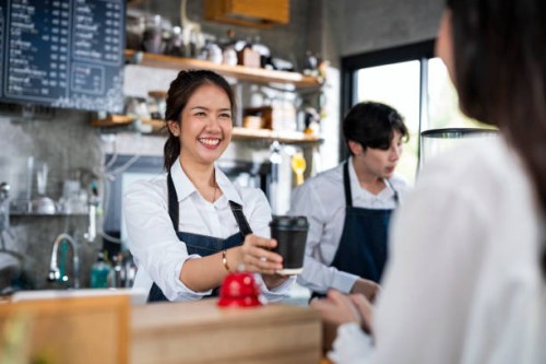 shot of a female barista serving a cup of coffee to a customer in a cafe counter. small business owner, service mind and customer service. - junk food stock pictures, royalty-free photos & images