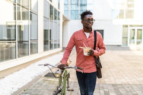 shot of a young man using a bicycle outdoors - junk food stock pictures, royalty-free photos & images