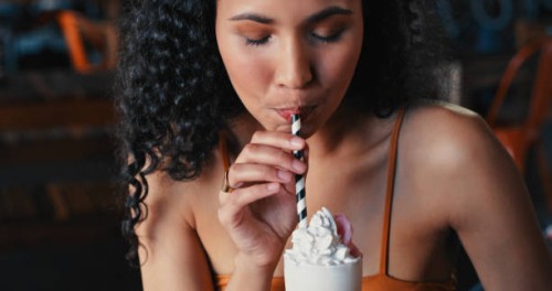 shot of a young woman enjoying a delicious milkshake at a diner - junk food stock pictures, royalty-free photos & images