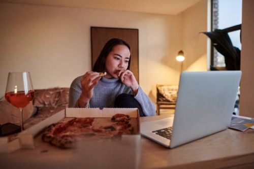 shot of a young woman having pizza while working from home - junk food stock pictures, royalty-free photos & images