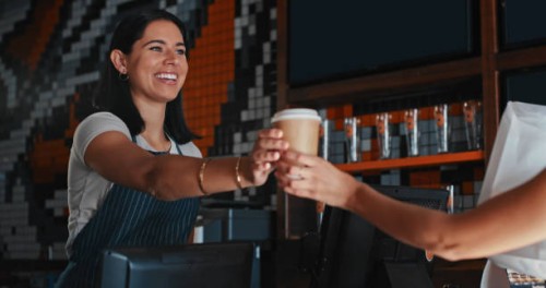 shot of a young woman serving a customer a cup of coffee at a cafe - junk food stock pictures, royalty-free photos & images