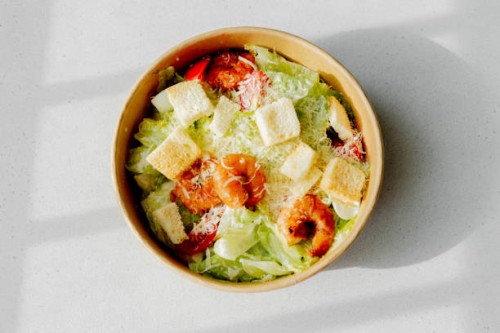 shrimp salad. healthy seafood caesar salad with prawns on white background. top view - junk food stock pictures, royalty-free photos & images