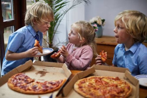 siblings eating pizza together - junk food stock pictures, royalty-free photos & images