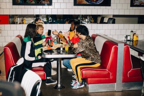 side view of male and female friends talking at table in cafe - junk food stock pictures, royalty-free photos & images