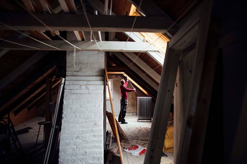side view of man working in attic under construction - home decoration stock pictures, royalty-free photos & images
