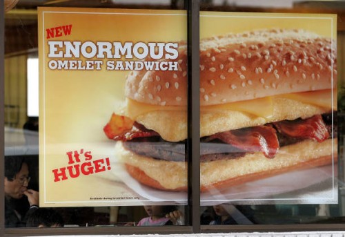 Sign hangs in a window for Burger King's new "Enormous Omelet Sandwich" at a Burger King March 31, 2005 in Niles, Illinois. The new "Enormous Omelet...