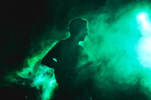 silhouette of a guitarist on stage light and smoke effects. - concert stock pictures, royalty-free photos & images