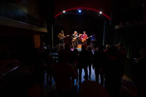 silhouetted audience watching band performing onstage - concert stock pictures, royalty-free photos & images