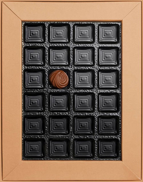 single chocolate in empty box, overhead view - junk food stockfoto's en -beelden