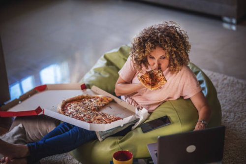 single woman watching online tv and eating pizza - junk food stock pictures, royalty-free photos & images