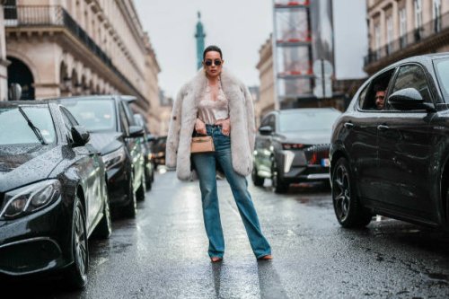 Sira Pevida wears white oversized sherpa aviator jacket, light blue washed skinny denim jean pants, shiny black pointed toe knee high heels, dark...