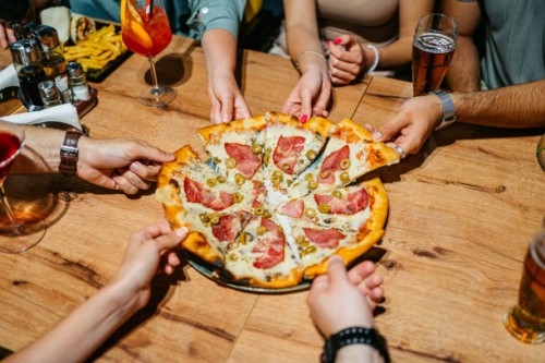 six young people taking a slice of pizza in a pub - food stock pictures, royalty-free photos & images
