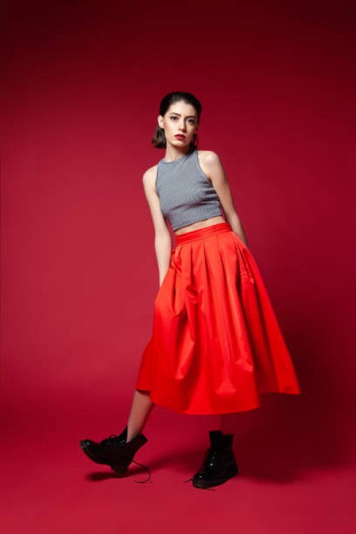 skinny young woman in red skirt posing in studio - fashion stock pictures, royalty-free photos & images