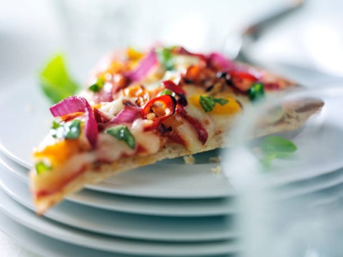 slice of pizza on stack of plates - junk food stockfoto's en -beelden