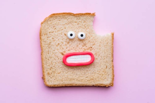 sliced bread with faces on pink background - junk food stock pictures, royalty-free photos & images